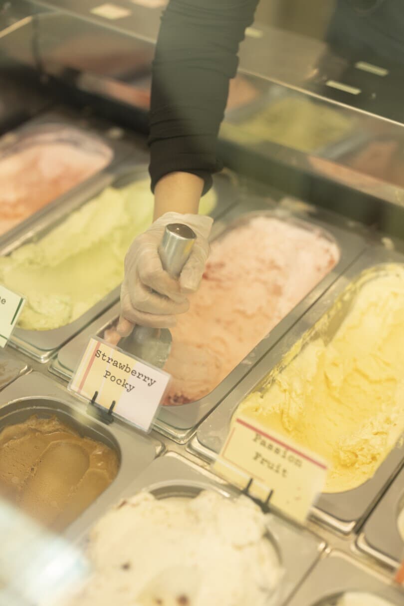 Hand scooping strawberry ice cream at Fika Fika Creamery in Ontario Ranch CA 810x1215